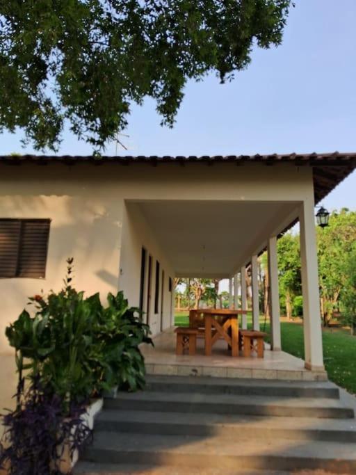a porch of a house with a table and chairs at Cute Rustic Cottage by the River in Caximba