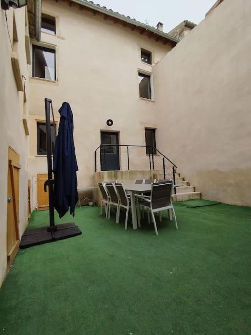 un patio avec une table et des chaises dans un bâtiment dans l'établissement Maison des Cordeliers, à Valréas