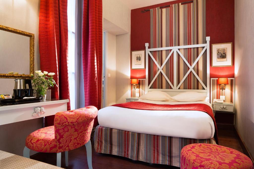 a hotel room with a bed and a chair at Hotel Louvre Bons Enfants in Paris