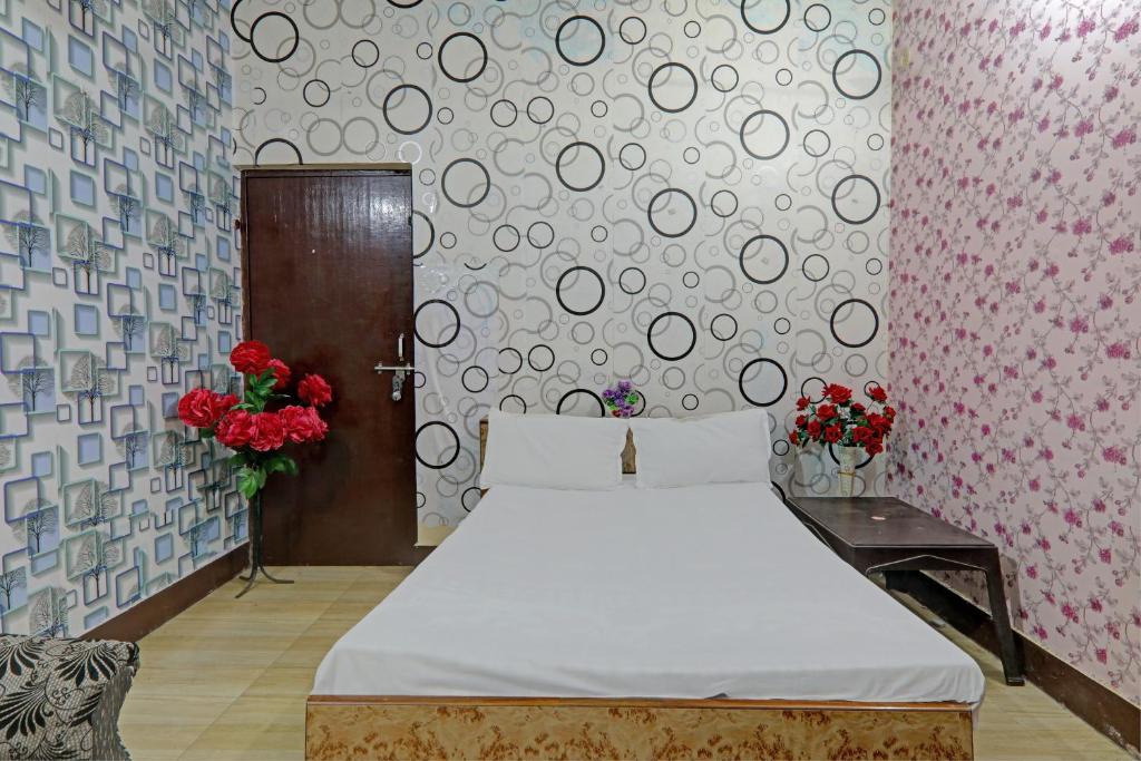 ein Schlafzimmer mit einem Bett und einer Wand mit Blumen in der Unterkunft OYO The Home in Lucknow
