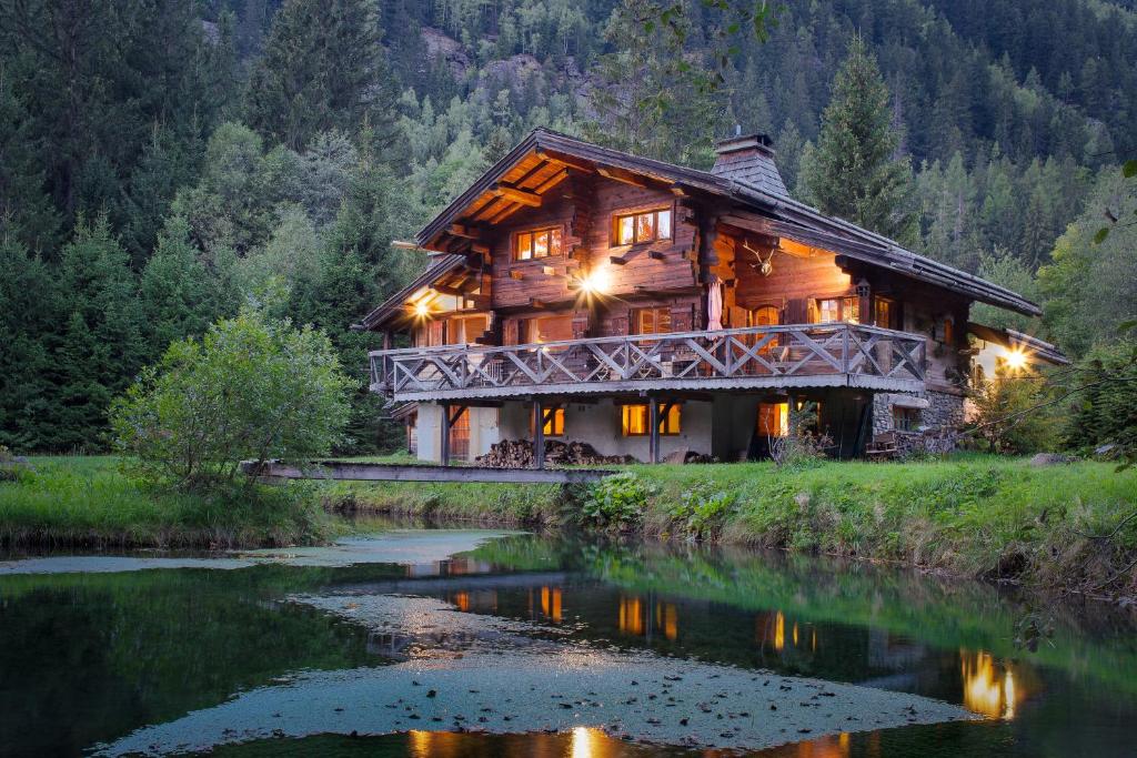 a log cabin with a river in front of it at Chalet Tré la Vieux - Happy Rentals in Chamonix-Mont-Blanc
