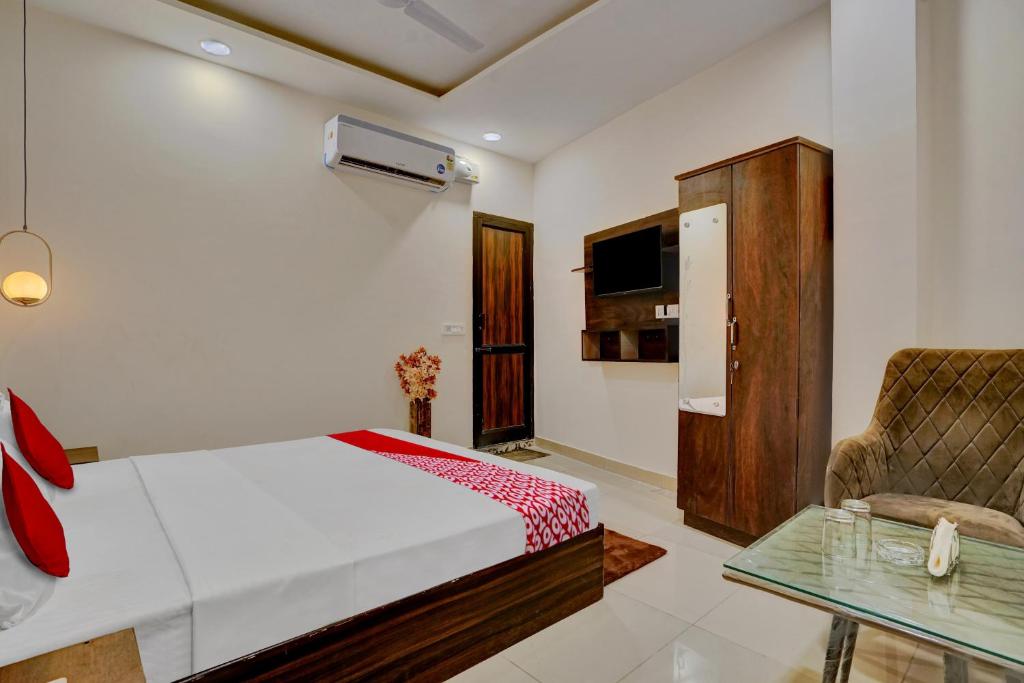 1 dormitorio con 1 cama, 1 silla y 1 mesa en Flagship Hotel Orchid, en Ludhiana