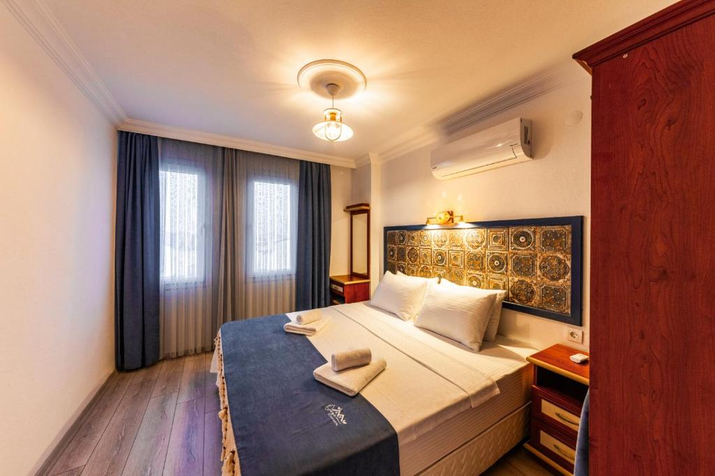 um quarto de hotel com uma cama com duas toalhas em Özgüm Suite Otel em Datça