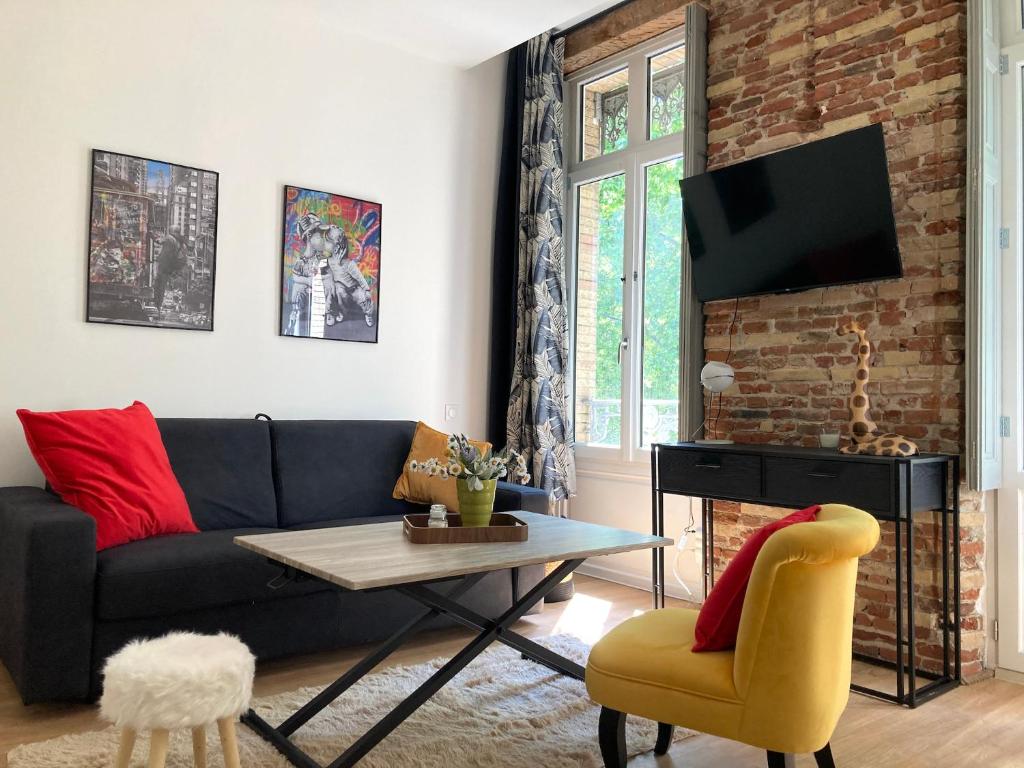 uma sala de estar com um sofá e uma mesa em Studio Luxine - 2 personnes - Vue sur le Canal du Midi em Toulouse