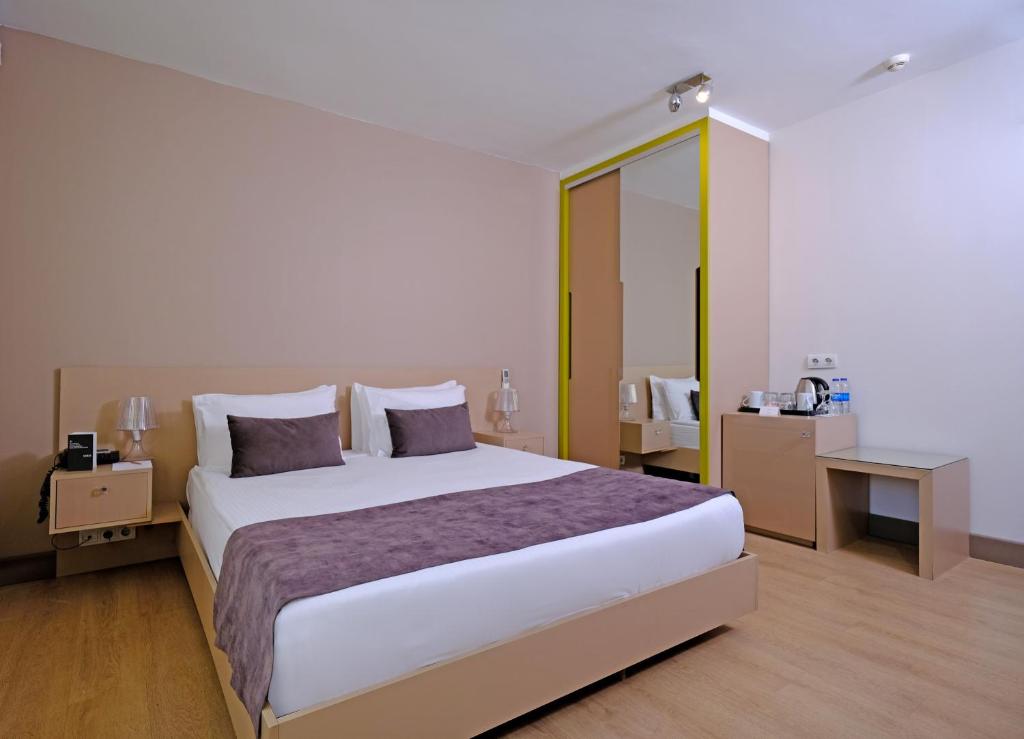 Cheya Besiktas Istanbul Bosphorus City Center Hotel & Suites في إسطنبول: غرفة نوم بسرير كبير ومرآة