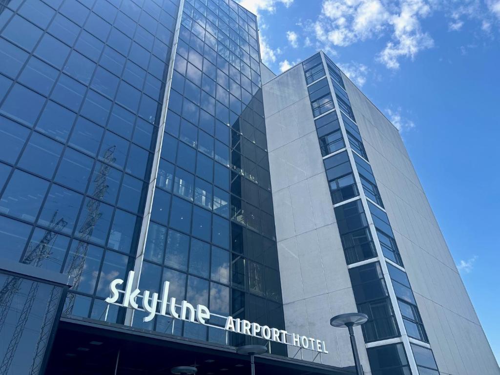 a tall glass building with a sign on it at Skyline Airport Hotel in Vantaa