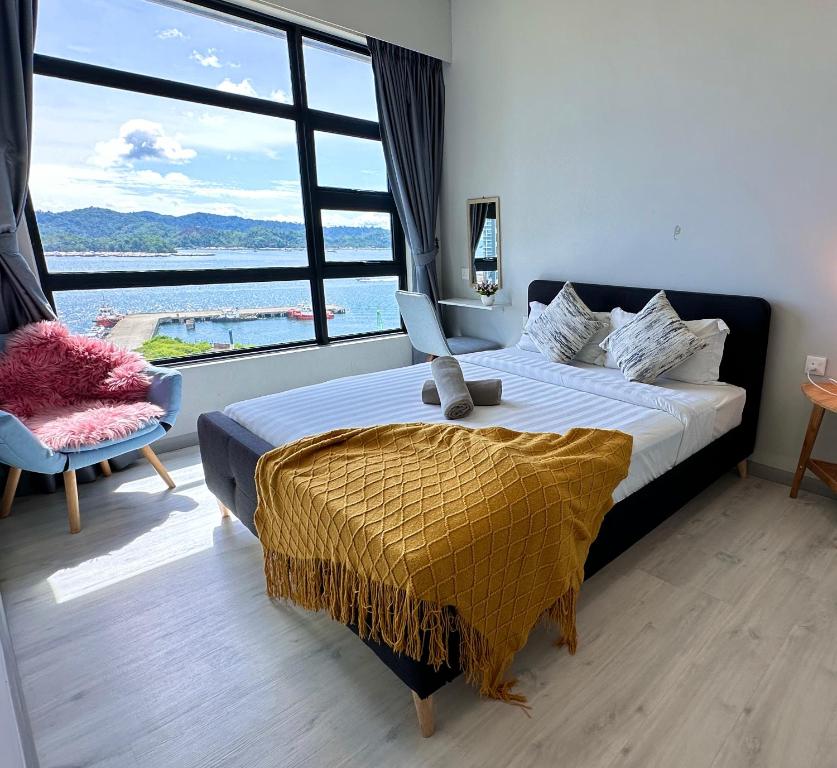 um quarto com uma cama e uma grande janela em JQ1 SEA & POOL or CITY View WIFI I WASHING MACHINE for Seaview unit I CUCKOO WATER Jesselton Quay by R2 em Kota Kinabalu