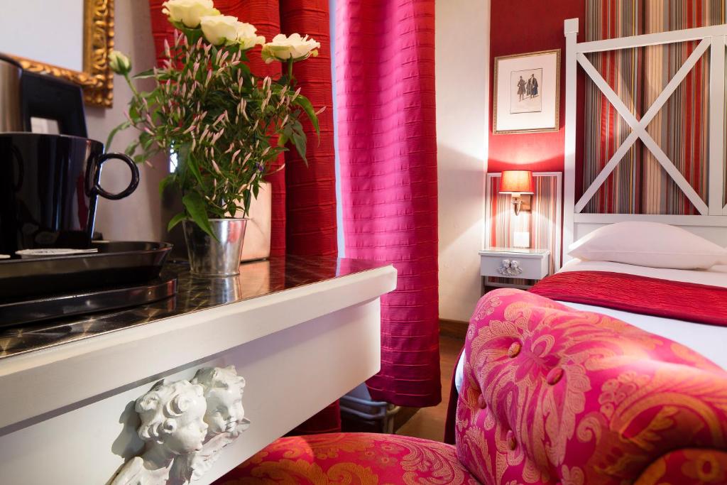 a hotel room with a bed and a table and a chair at Hotel Louvre Bons Enfants in Paris