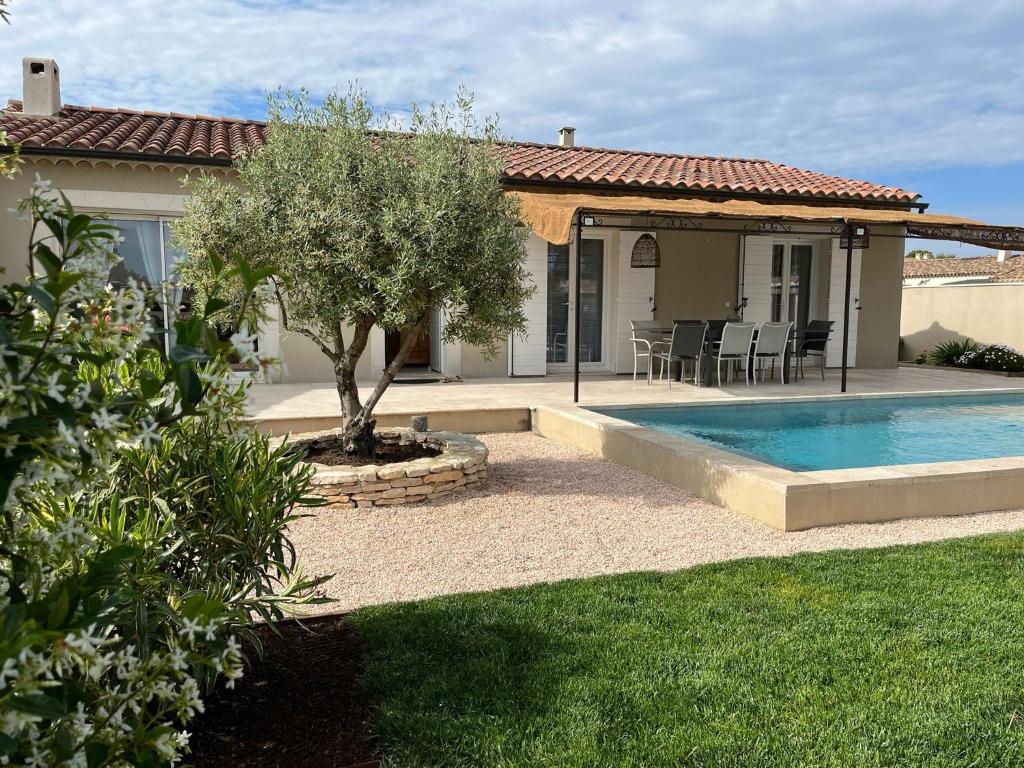 une maison avec une piscine dans une cour dans l'établissement Villa Provençale avec Piscine Chauffée, à Saint-Andiol