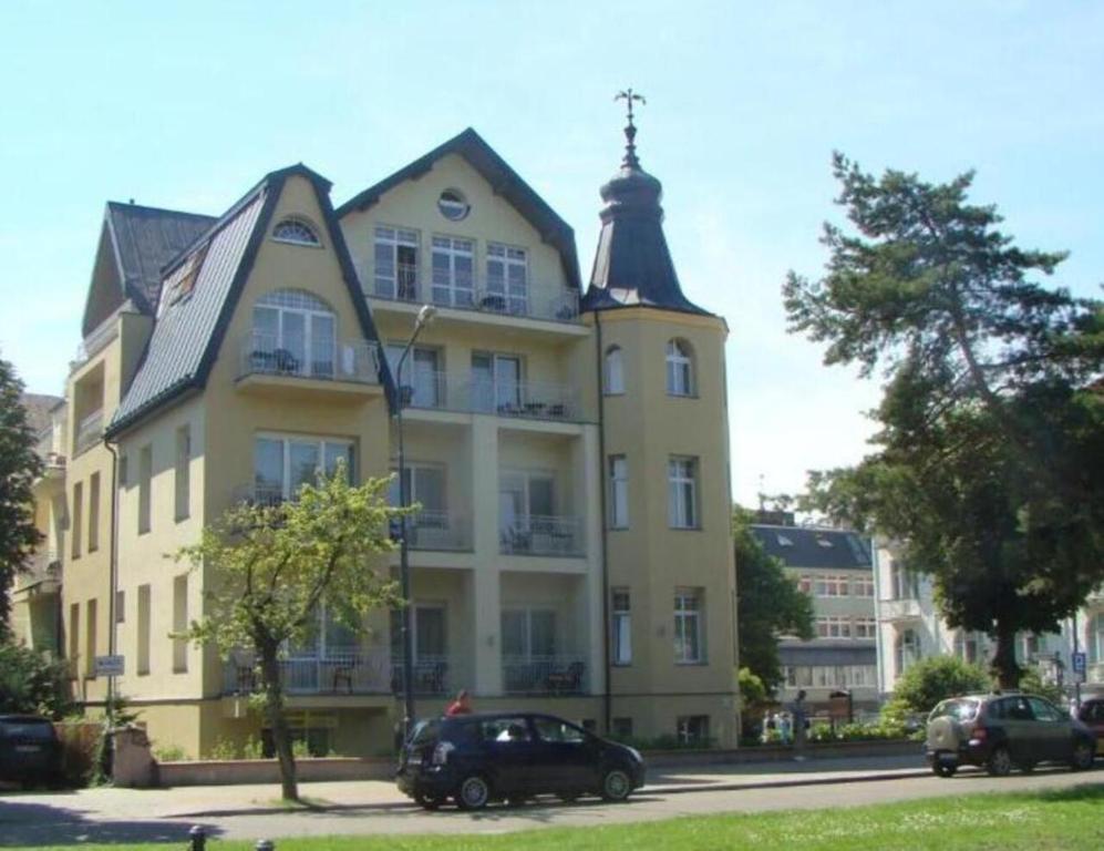 un gran edificio amarillo con una cruz encima en Villa Merry, en Świnoujście