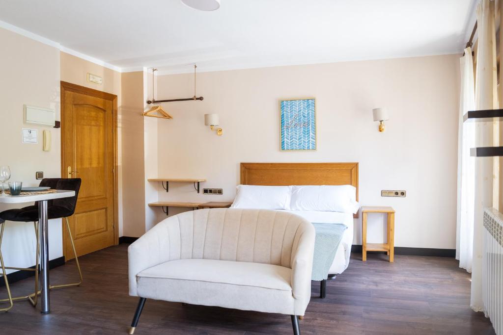 ヌエバ・デ・リャネスにあるApartamentos San Jorgeのベッドルーム(白いベッド1台、椅子付)