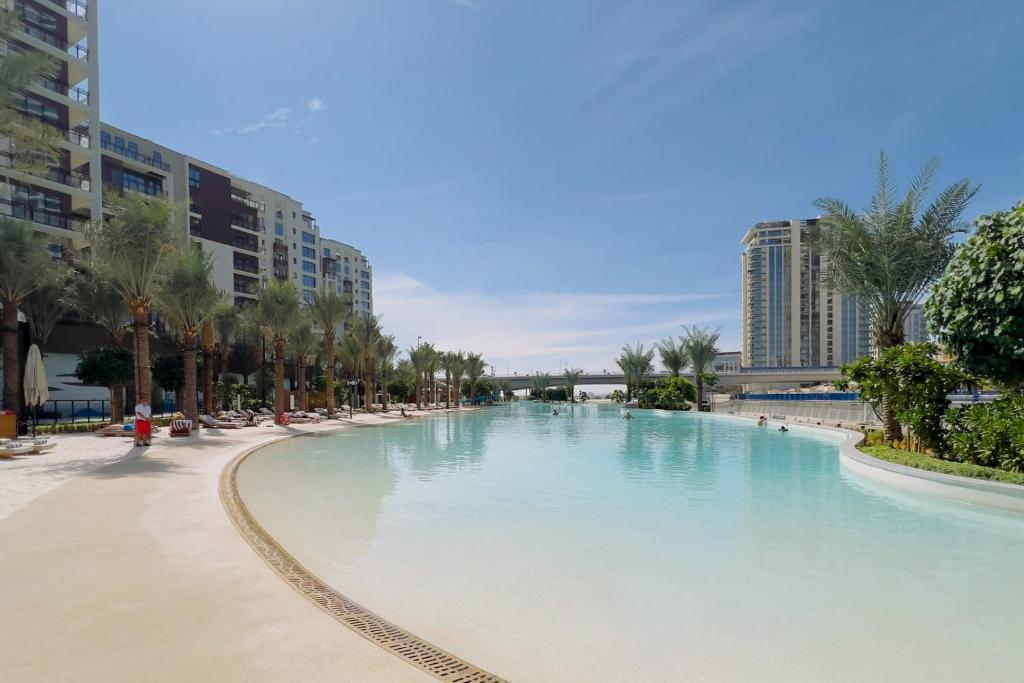 uma grande piscina com palmeiras e edifícios em GuestReady - Luxurious living in Dubai Creek em Dubai