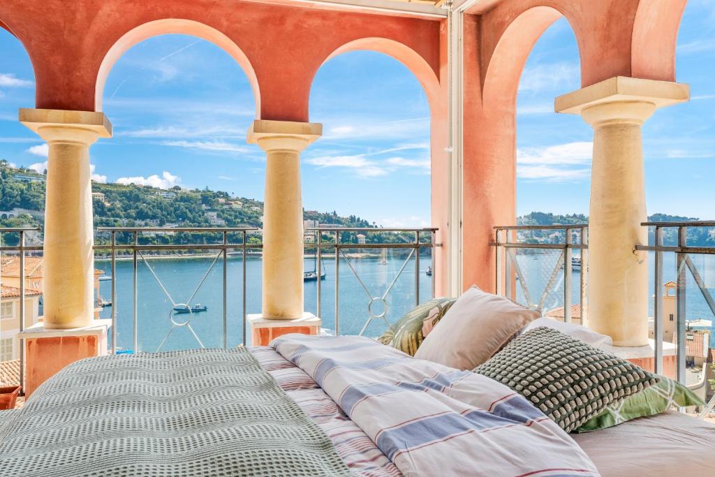 - un lit sur un balcon avec vue sur l'eau dans l'établissement Penthouse La Bellevue, à Villefranche-sur-Mer