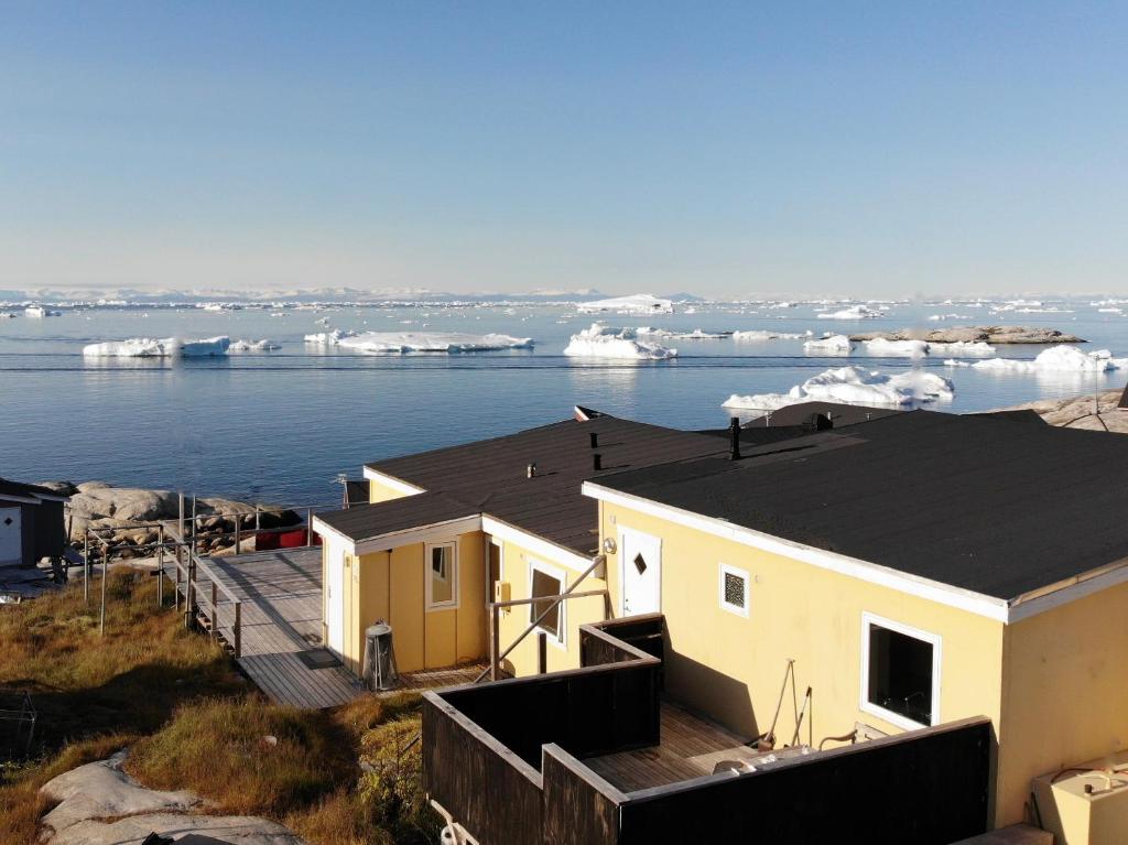 a house with an iceberg in the water at Modern seaview vacation house, Ilulissat in Ilulissat