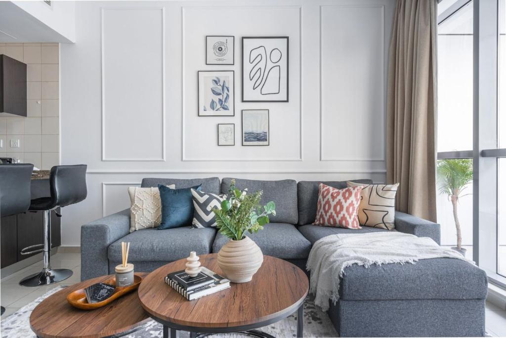 a living room with a blue couch and a table at GuestReady - Comfort Stay l Close To Marina Mall in Dubai