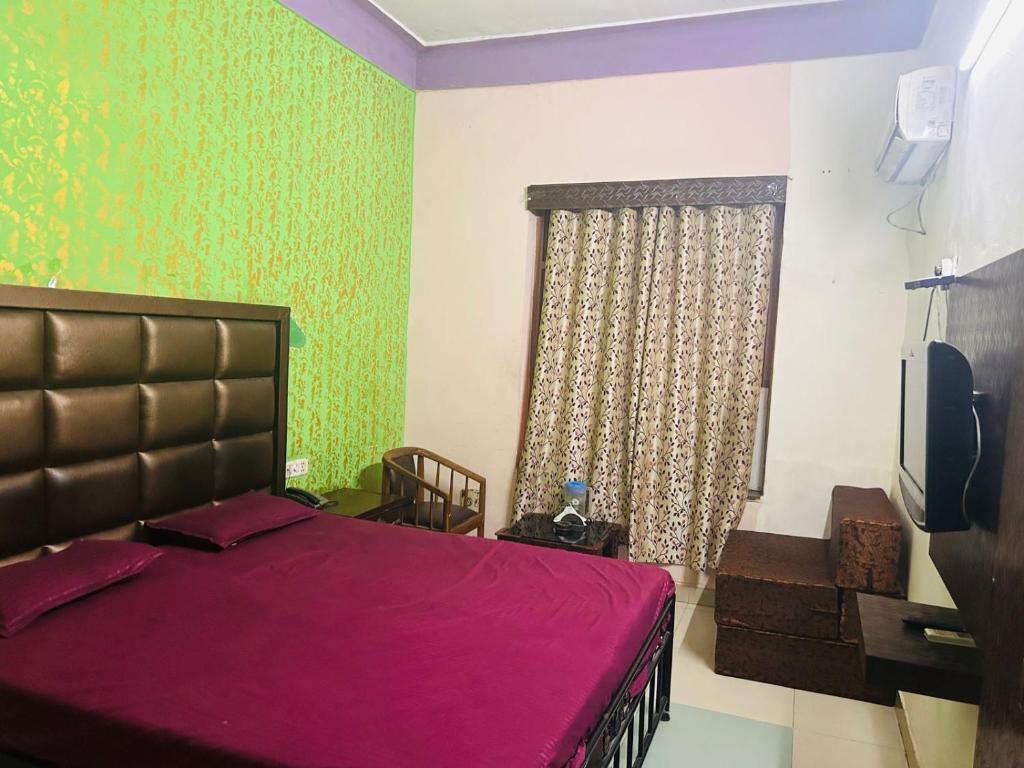 1 dormitorio con 1 cama y TV. en Hotel Krishna Palace, en Nueva Delhi