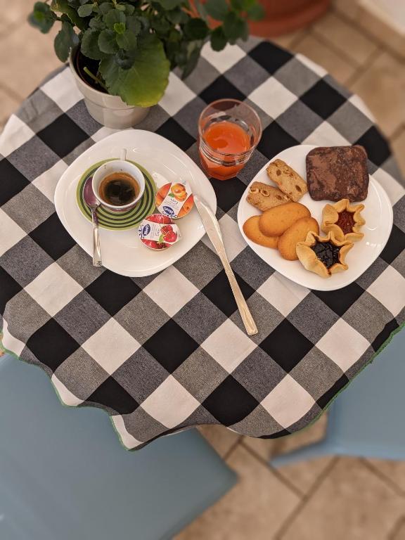Colazione servita su tovaglia a quadri con caffè, dolci e marmellate vista dall'alto