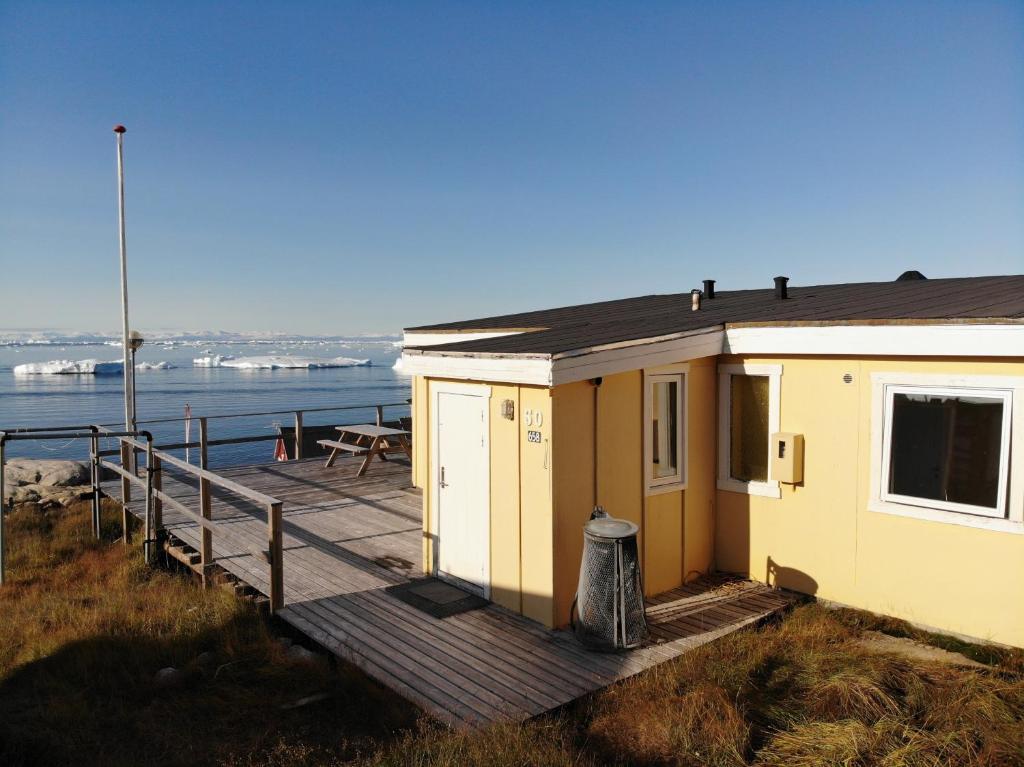 Grand seaview vacation house, Ilulissat في إيلوليسات: منزل صغير على الممر بجوار الماء