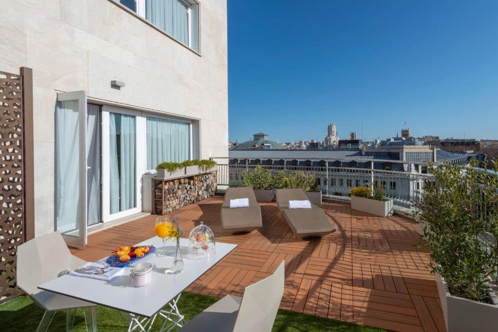 a patio with a table and chairs on a balcony at NH Collection Madrid Suecia in Madrid