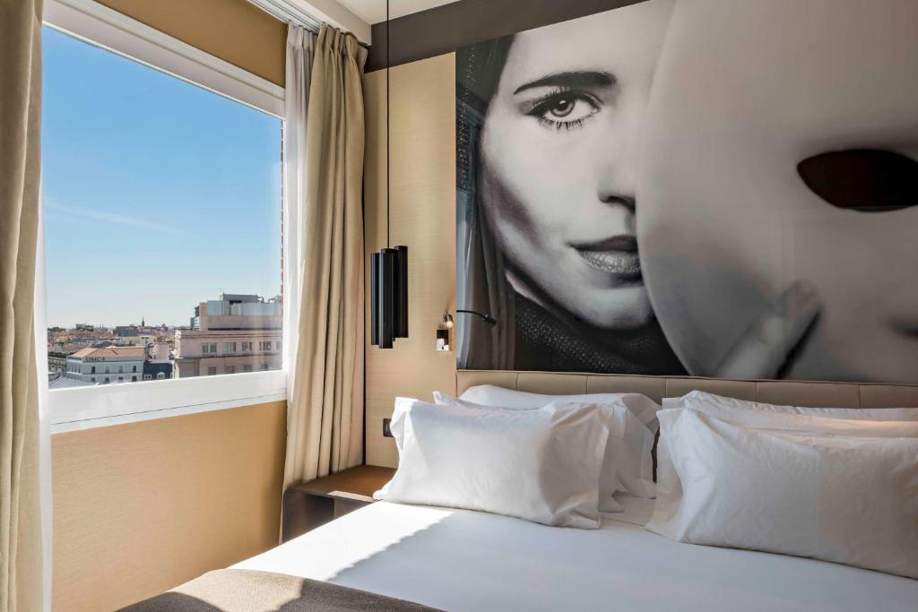 a bedroom with a large picture of a woman at NH Collection Madrid Suecia in Madrid