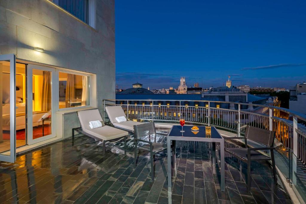 a balcony with a table and chairs on a building at NH Collection Madrid Suecia in Madrid