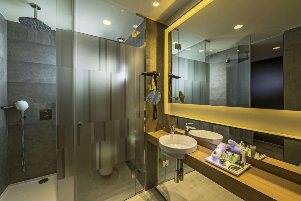 a bathroom with a sink and a mirror at NH Collection Madrid Suecia in Madrid