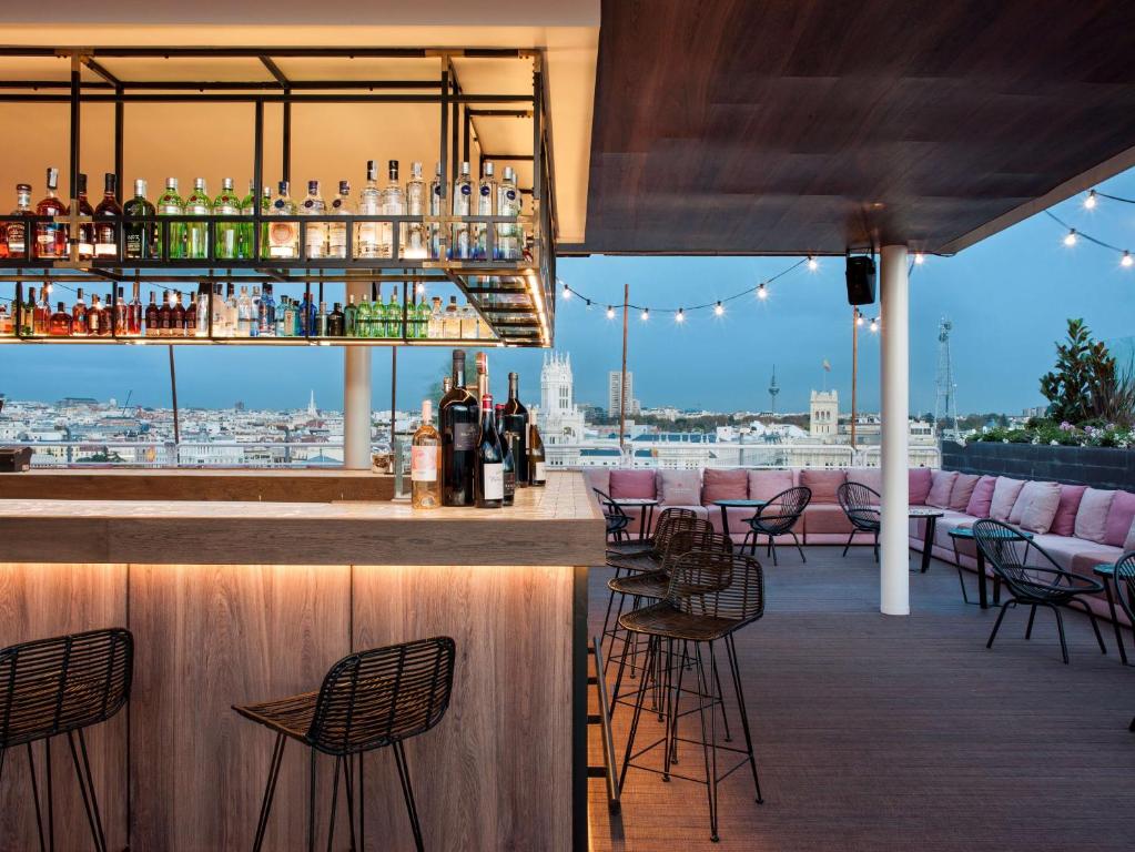 a bar with chairs and a view of the city at NH Collection Madrid Suecia in Madrid