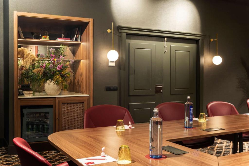 a room with a table and chairs and a door at NH Collection Madrid Suecia in Madrid
