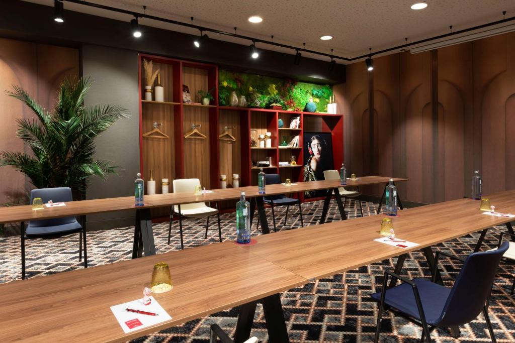 a conference room with wooden tables and chairs at NH Collection Madrid Suecia in Madrid
