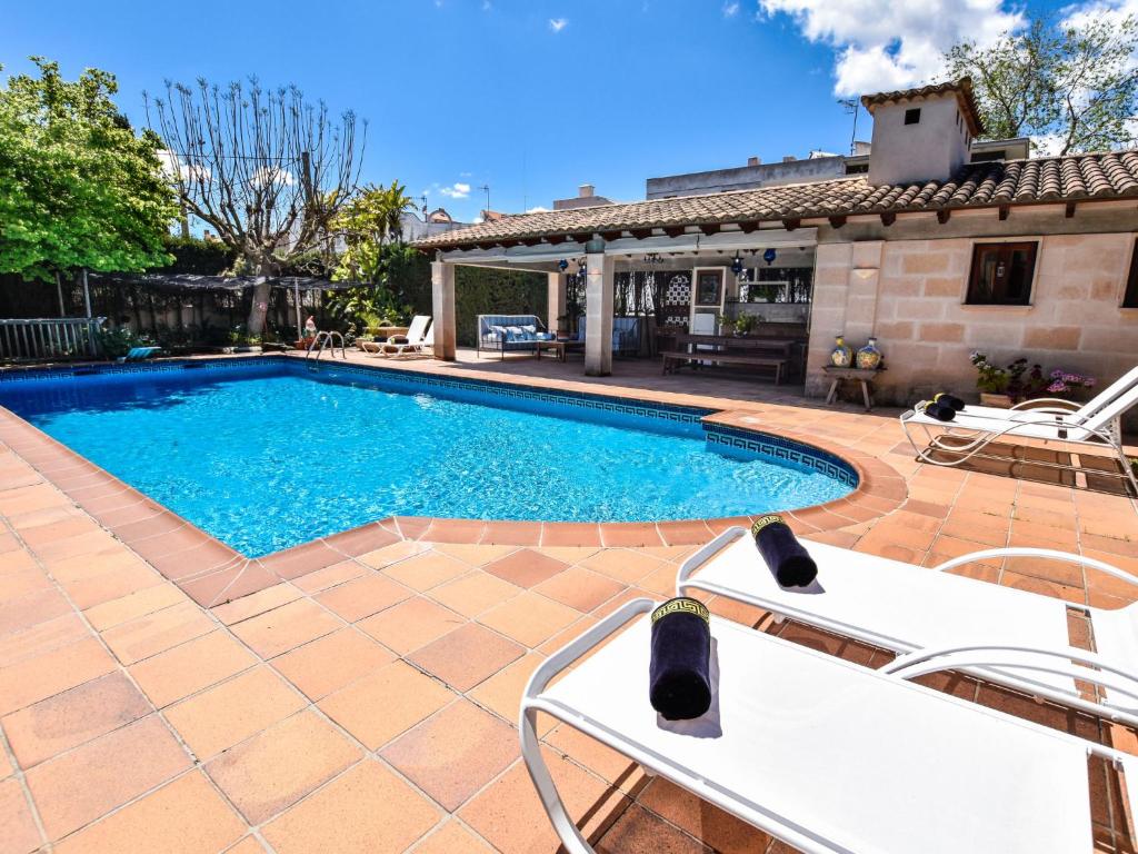 una piscina con 2 sillas frente a una casa en Villa Can Joan by Interhome en Lloseta