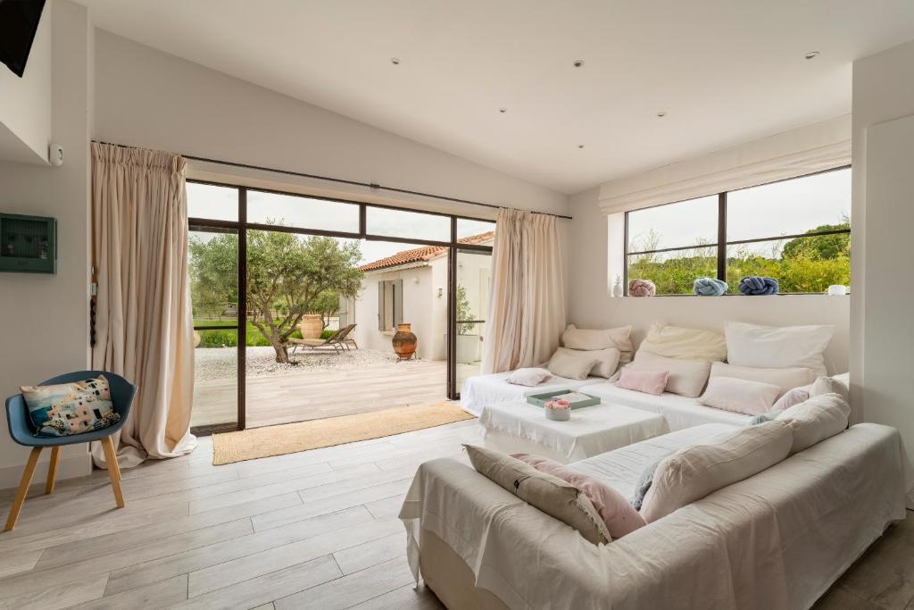 ein Wohnzimmer mit einem großen Sofa und einem großen Fenster in der Unterkunft Le Cabanon de Modène in Modène