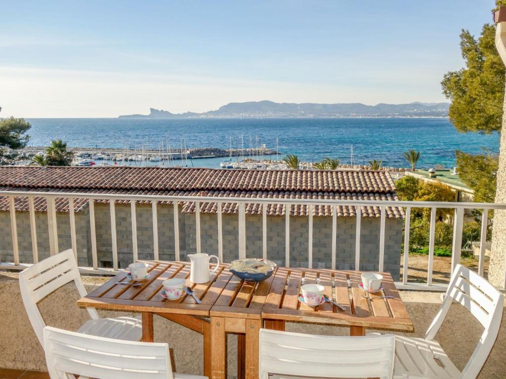d'une table et de chaises en bois sur un balcon donnant sur l'océan. dans l'établissement Apartment Les Aigues Marines-29 by Interhome, à Saint-Cyr-sur-Mer