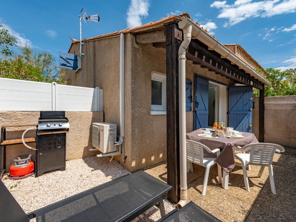une petite maison avec une table et un poêle dans l'établissement Holiday Home Les Capellanes-4 by Interhome, à Saint-Cyprien