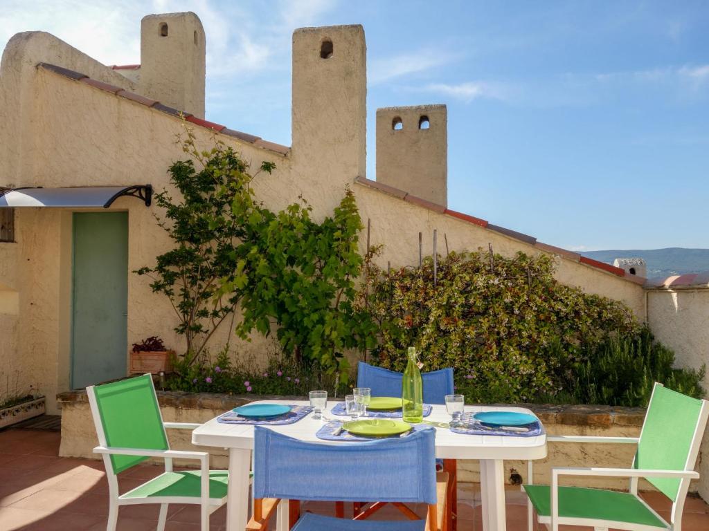 une table et des chaises sur une terrasse en face d'un bâtiment dans l'établissement Apartment Hameau la Madrague-4 by Interhome, à Saint-Cyr-sur-Mer
