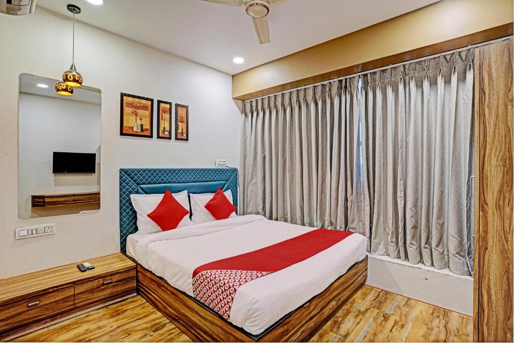 a bedroom with a bed and a window at OYO Hotel Green Signature in Surat