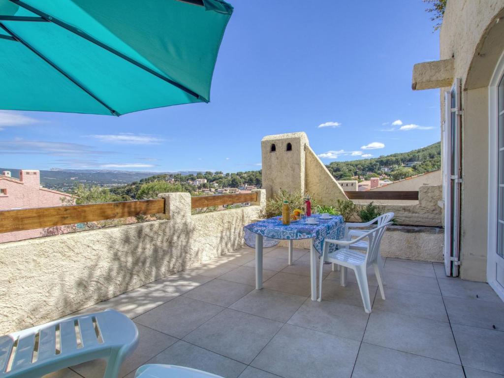une terrasse avec une table, des chaises et un parasol dans l'établissement Apartment Hameau la Madrague-8 by Interhome, à La Madrague