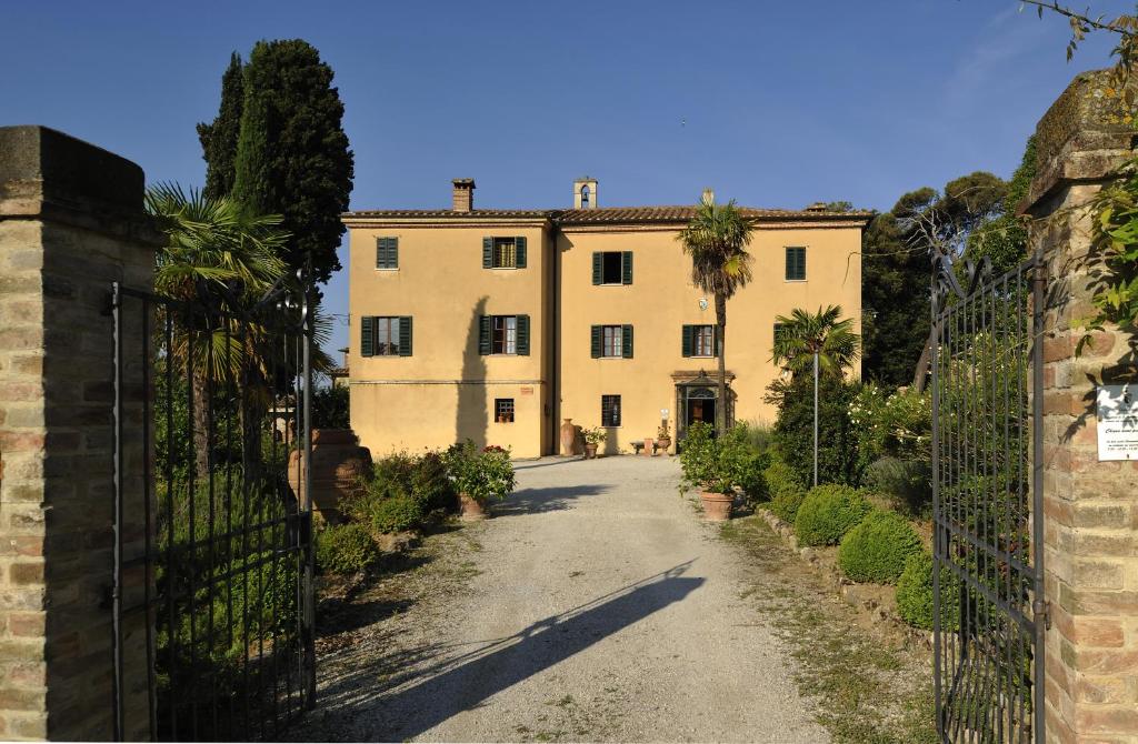 un bâtiment avec un portail en face d'une allée. dans l'établissement Hotel Borgo Casabianca, à Serre di Rapolano