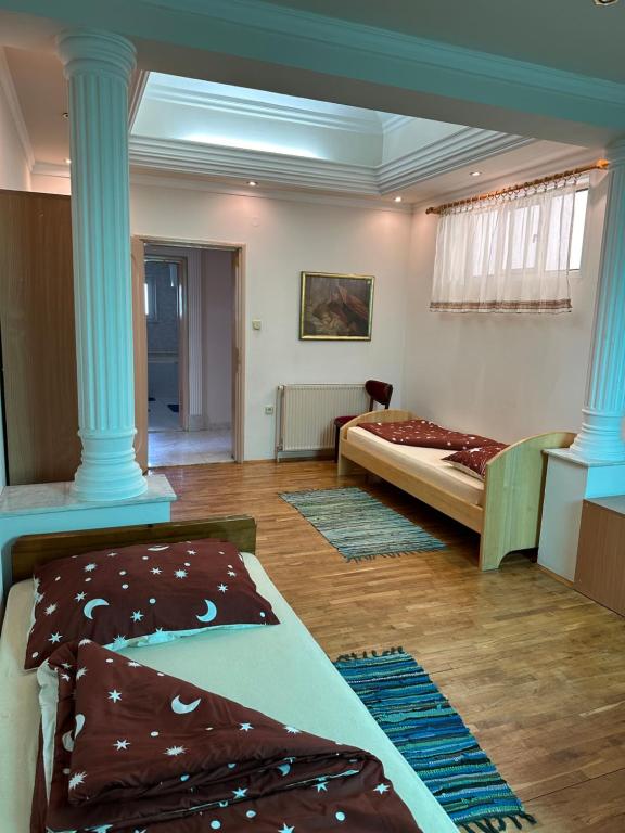 Habitación con 2 camas y columnas azules en Villa Oaza, en Bela Crkva