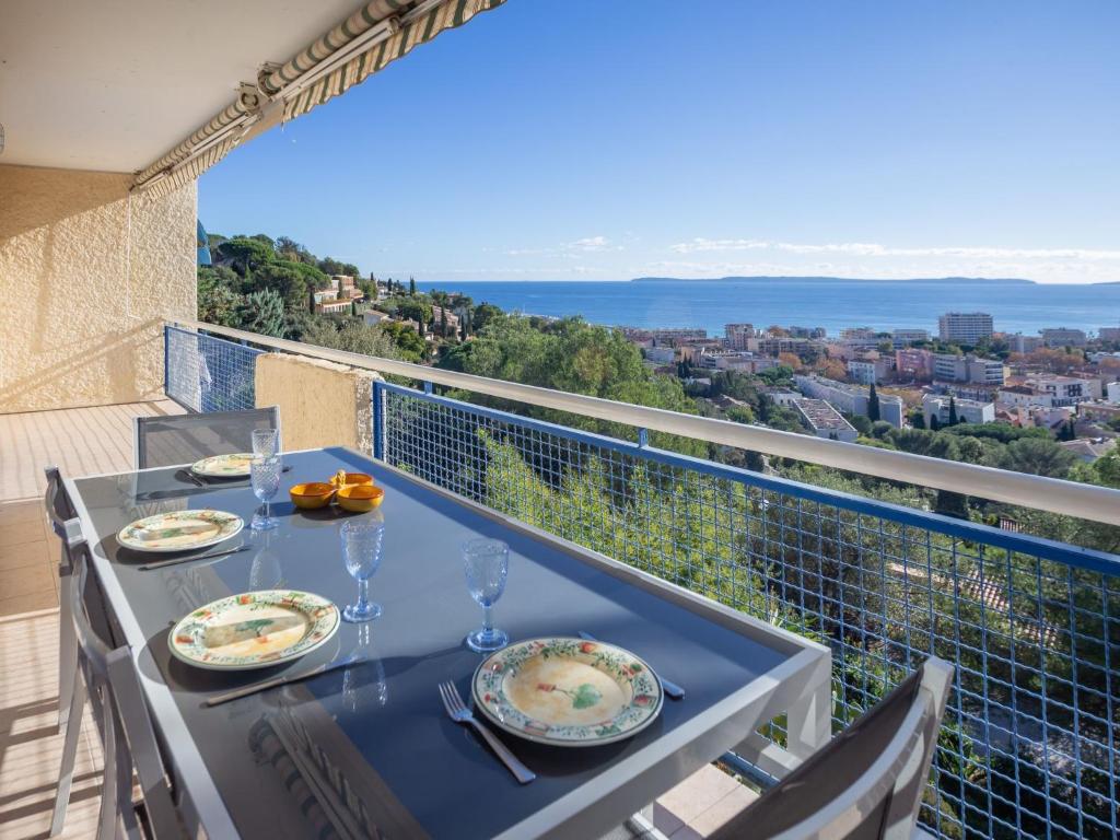 une table avec des assiettes de nourriture sur un balcon dans l'établissement Apartment Les Alizées by Interhome, au Lavandou