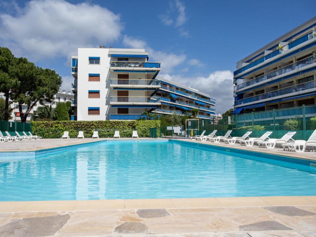 une piscine avec des chaises longues et un bâtiment dans l'établissement Apartment le grand large-2 by Interhome, à Cagnes-sur-Mer