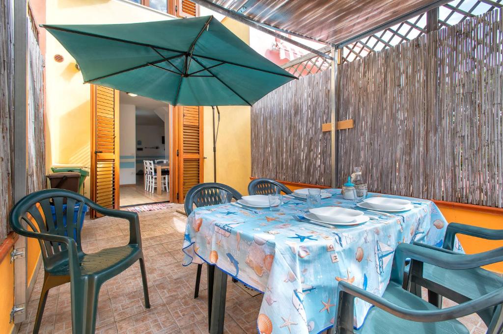 a table with a blue table cloth and a green umbrella at Holiday Cala Sant'andrea in Stintino
