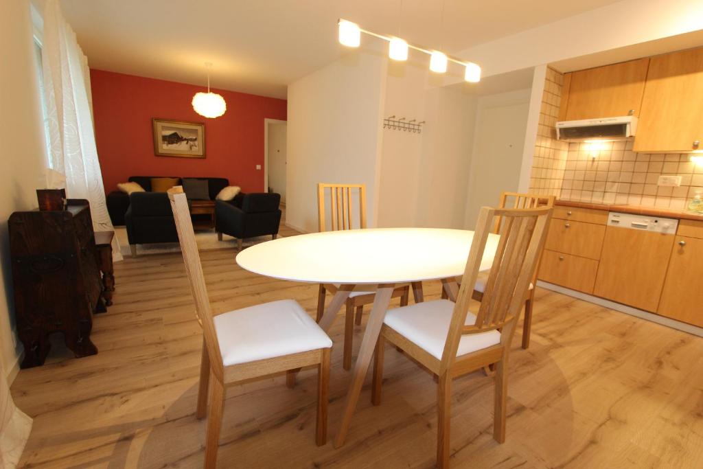 eine Küche und ein Wohnzimmer mit einem Tisch und Stühlen in der Unterkunft Le Castel 1 in Chateau-d'Oex