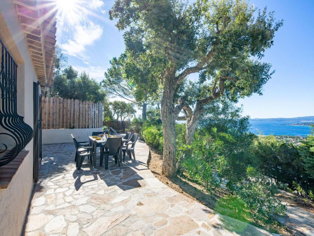 d'une terrasse avec une table, des chaises et un arbre. dans l'établissement Holiday Home La Bartavelle by Interhome, aux Issambres