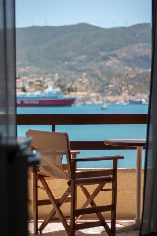 a table and chair on a balcony with a view of the ocean at Villa Irene in Poros