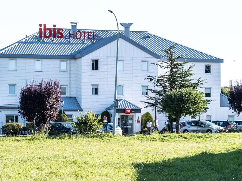 a large white building with a sign on it at ibis Vesoul in Vesoul