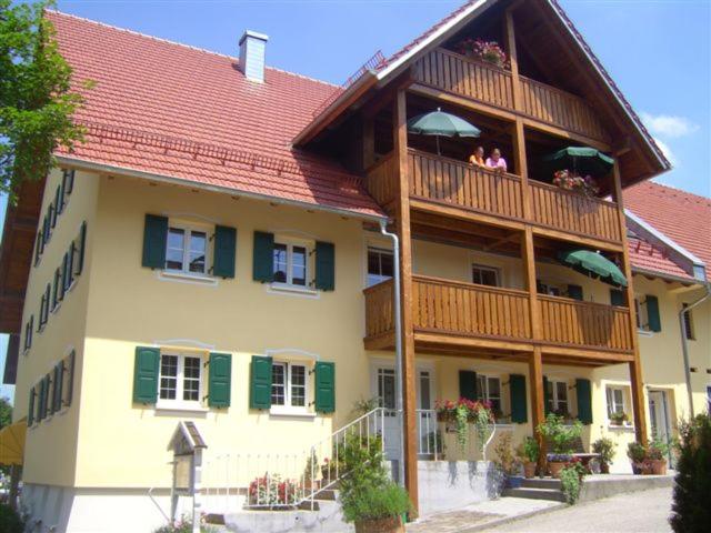 ein Gebäude mit Menschen, die auf einem Balkon sitzen in der Unterkunft Ferienwohnungen Roiser in Bad Wörishofen