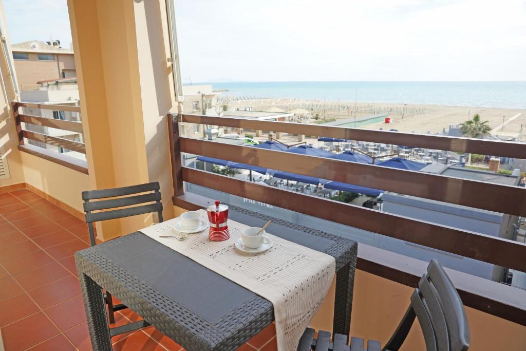 stół i krzesła na balkonie z widokiem na plażę w obiekcie Residence La Rosa di Nettuno w mieście Marina di Grosseto