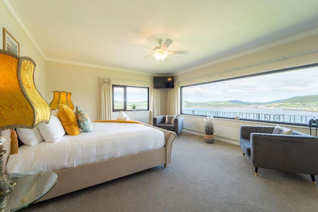 a bedroom with a large bed and a large window at Dingle Bay Nest in Dingle