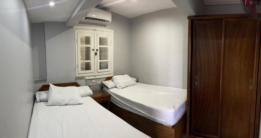 a small room with two beds and a cabinet at L’amour Hotel apartment in Marsa Matruh