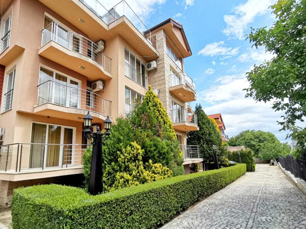 an apartment building with a hedge in front of it at Twins Palace ApartHotel in Saints Constantine and Helena